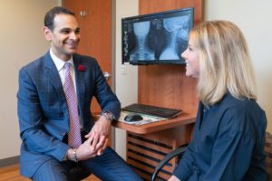 Dr. Mark Mikhael sitting with patient