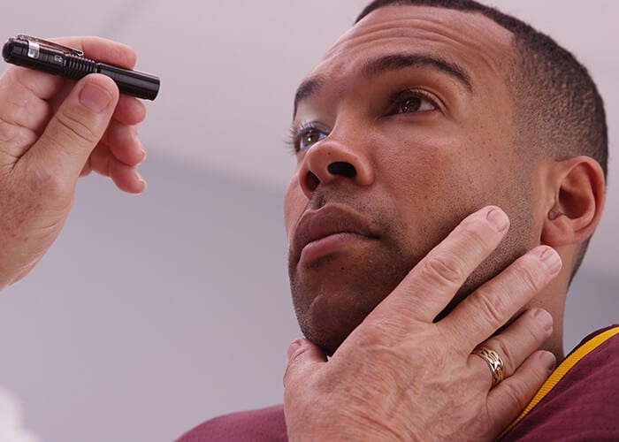 Doctor performing concussion test on athlete