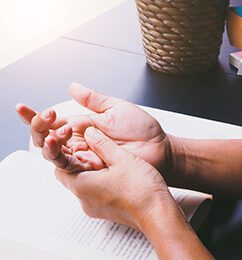 Person grasping hand over book