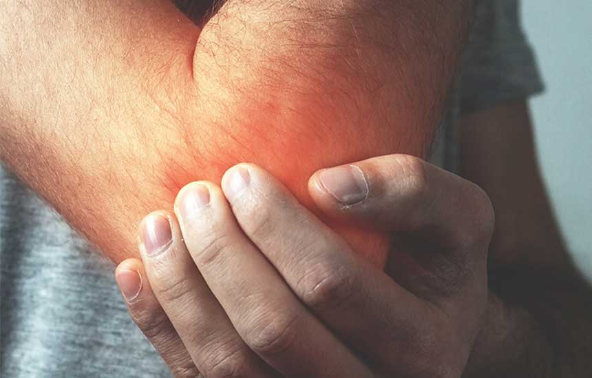 man holding elbow in pain