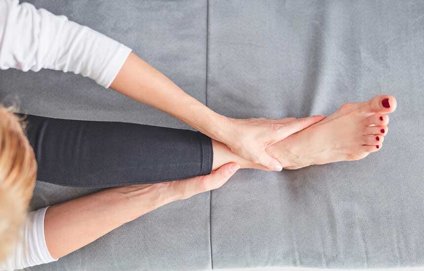 hands holding ankle in pain